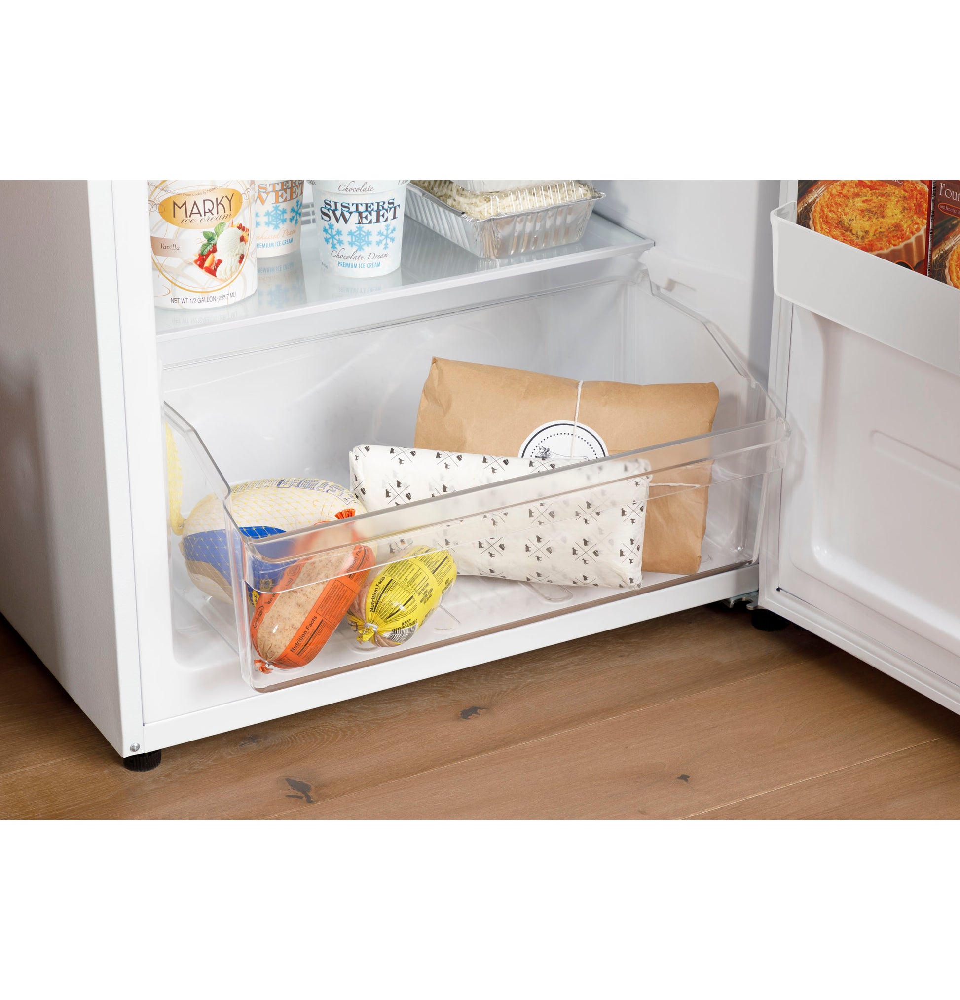 Clear freezer drawer with packaged frozen foods inside bottom compartment of upright freezer from appliances collection
