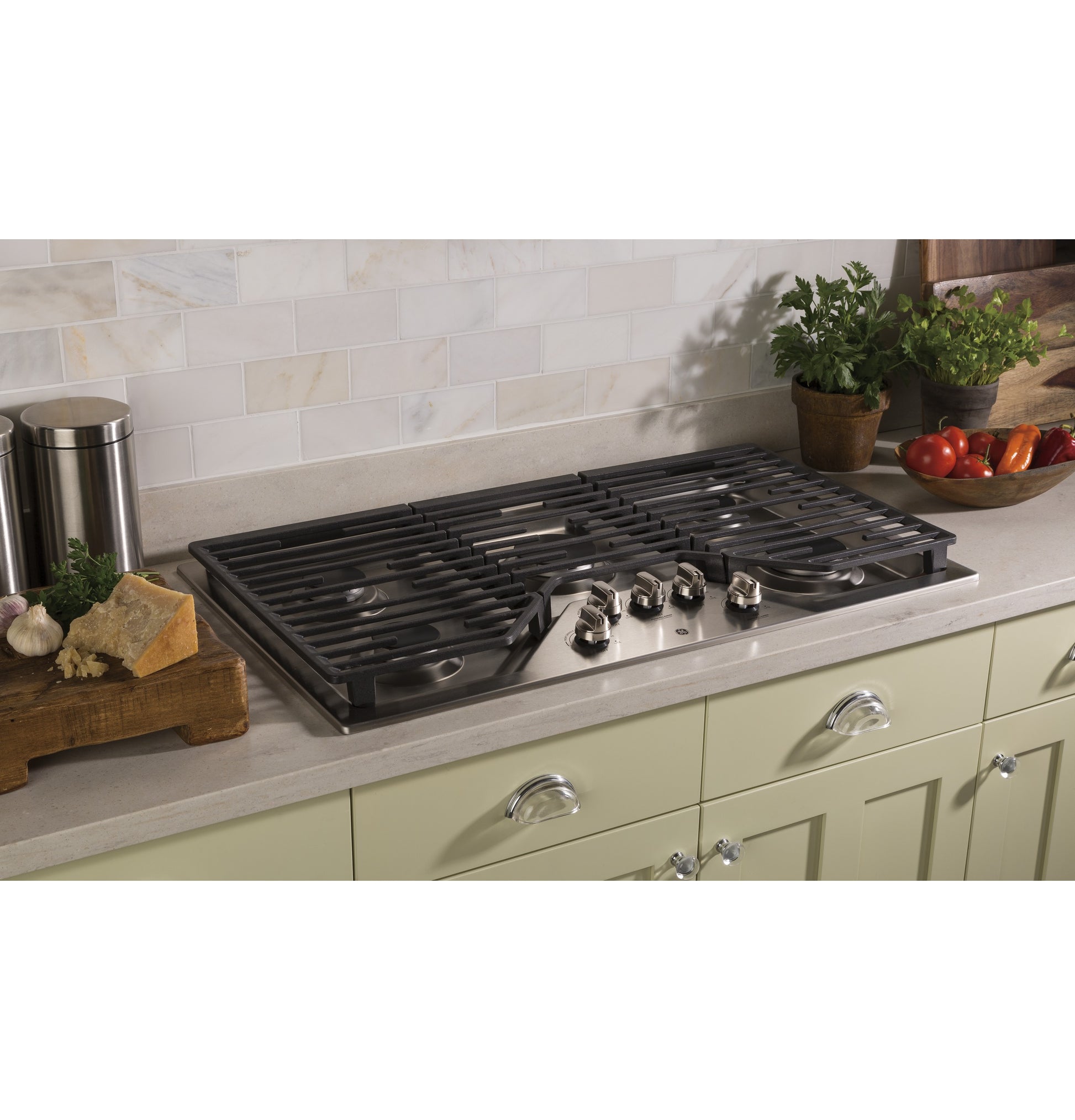 Built-in stainless steel gas cooktop with five burners and dishwasher-safe grates in a modern kitchen setting