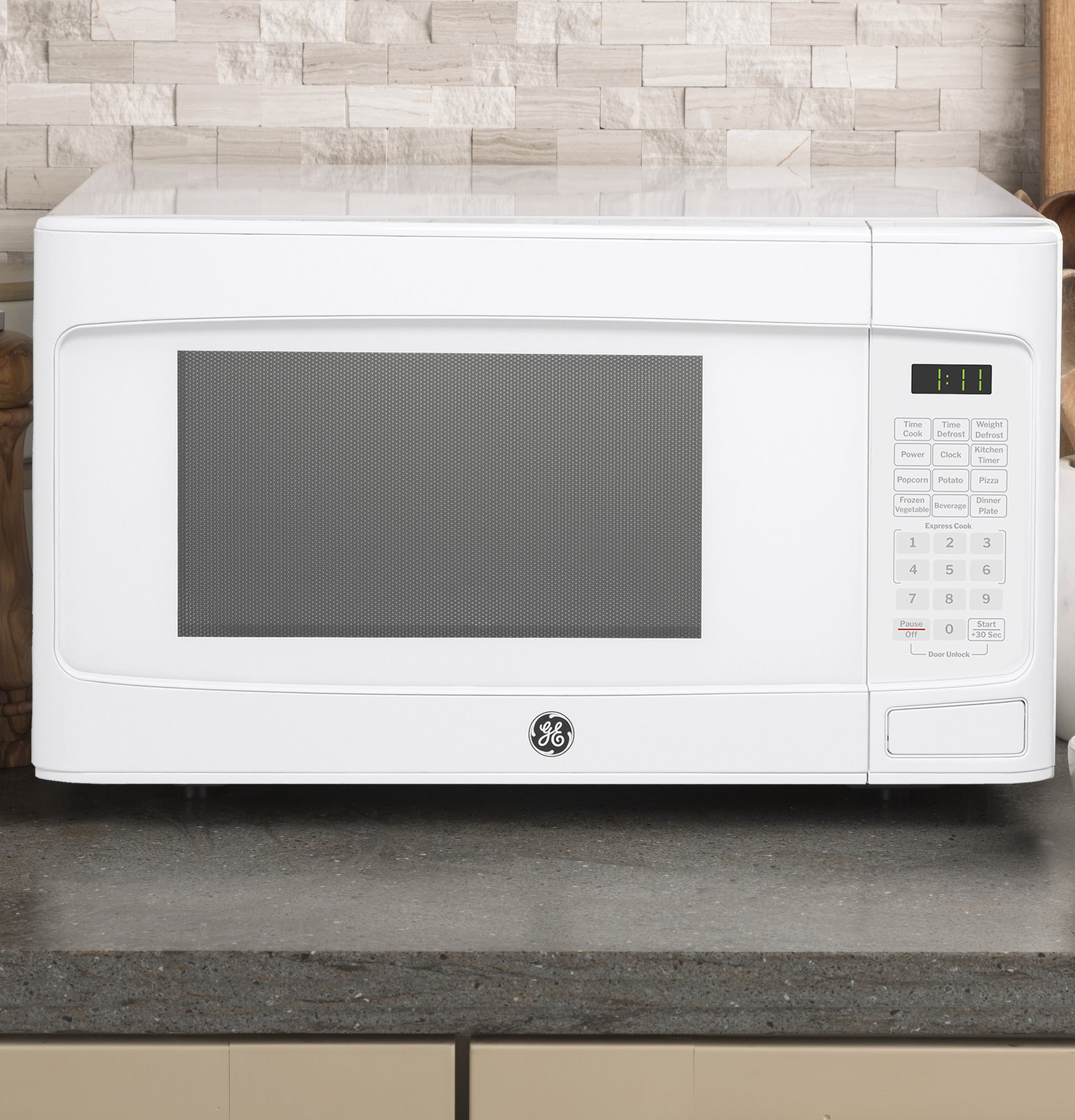 White GE microwave oven on kitchen countertop with digital control panel, part of kitchen appliances and countertop microwaves collection