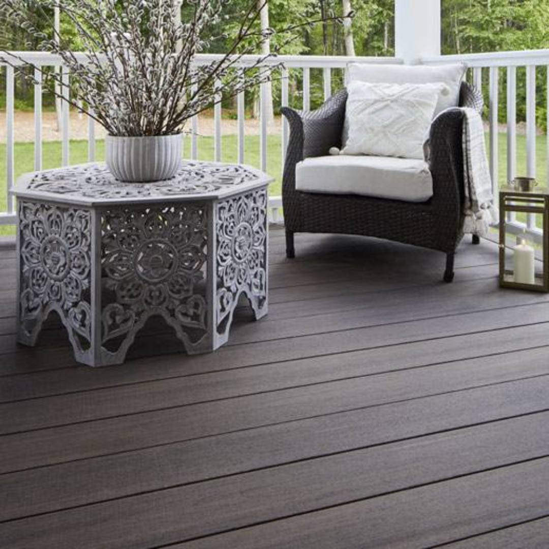 Outdoor seating area with cushioned chair and decorative metal table on TimberTech grooved deck boards