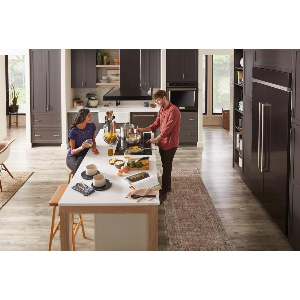 Bright modern kitchen with dark cabinetry, large island, 36-inch canopy hood, and KitchenAid appliances from Range Hoods collection
