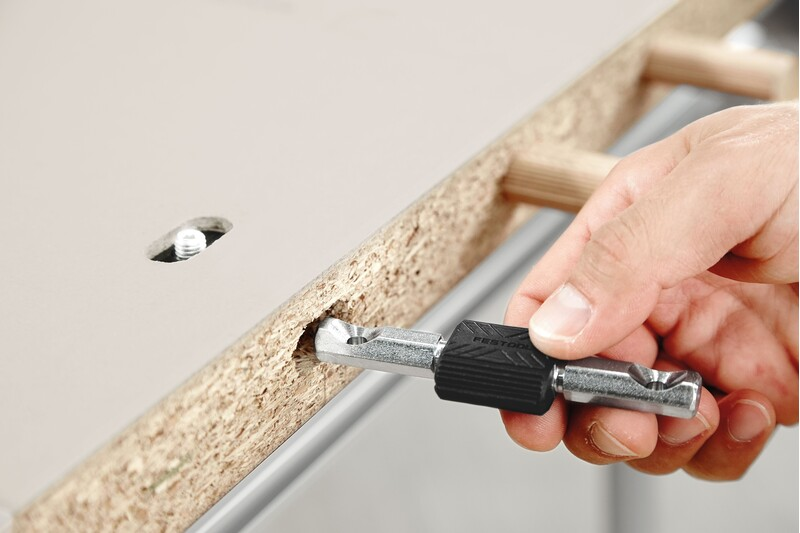 Hand using Festool double bolt connector tool to join particleboard in woodworking tool accessories collection