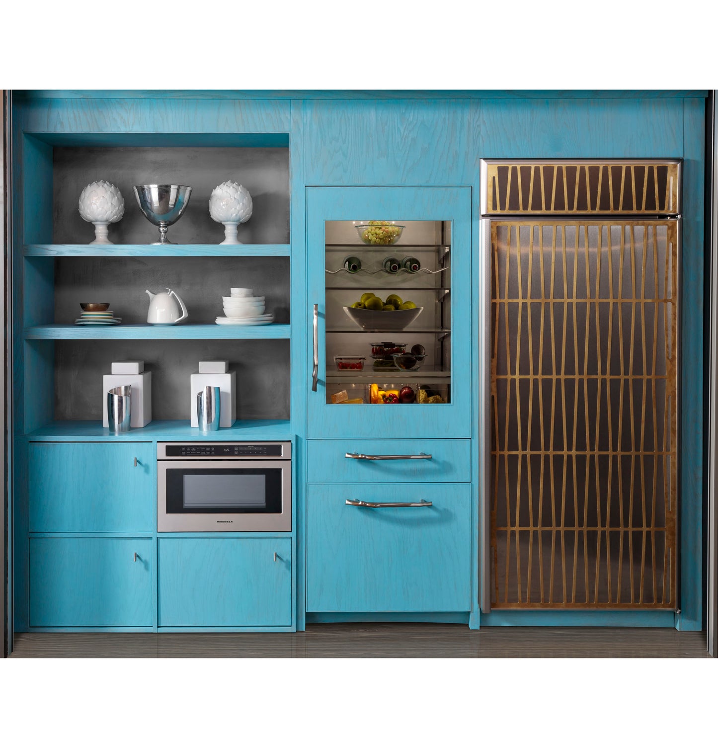 Blue kitchen cabinetry with built-in microwave drawer, glass-front wine cooler, and decorative gold-accented refrigerator door