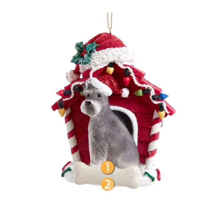 Gray schnauzer dog figurine wearing Santa hat in festive dog house ornament decorated with holiday lights and holly