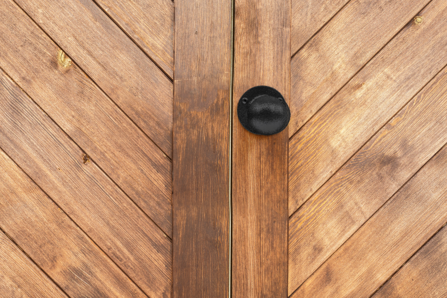Black rounded gate knob mounted on textured wooden gate for door and gate hardware in home improvement tools under $50