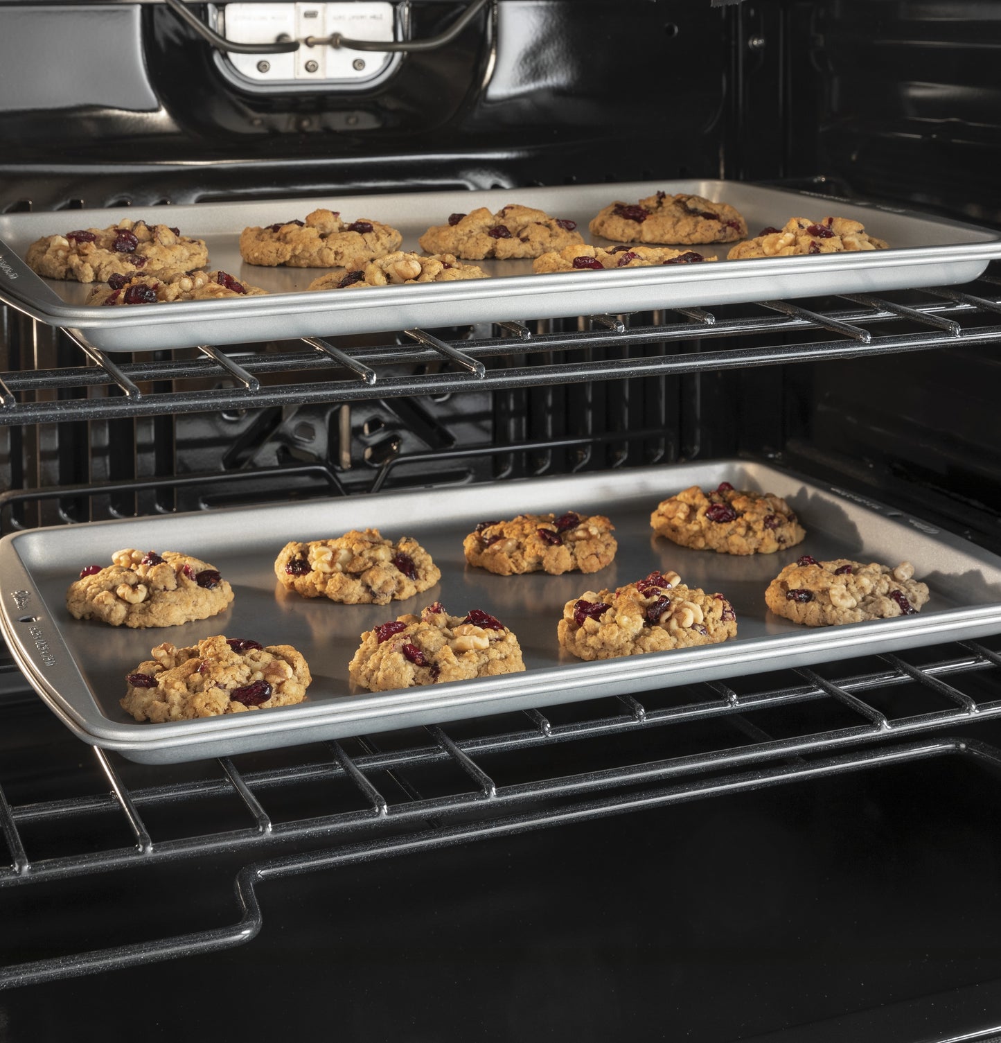 Two trays of cookies baking inside a black smart built-in wall oven from kitchen appliances collection
