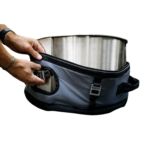 Gray padded Breeo Y Series transit case being secured around stainless steel fire pit for outdoor living and patio use