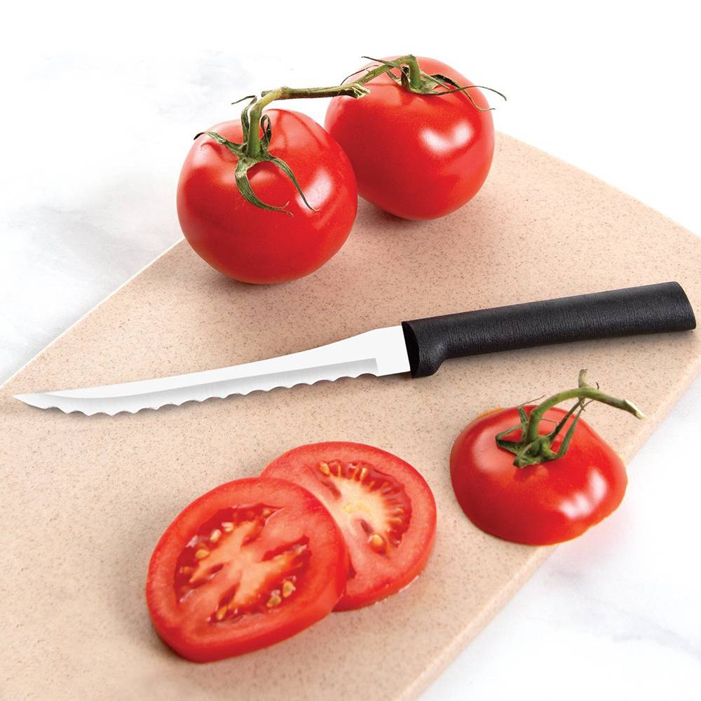 Serrated blade slicer with black handle cutting fresh tomato on tan cutting board in kitchenware collection under $50