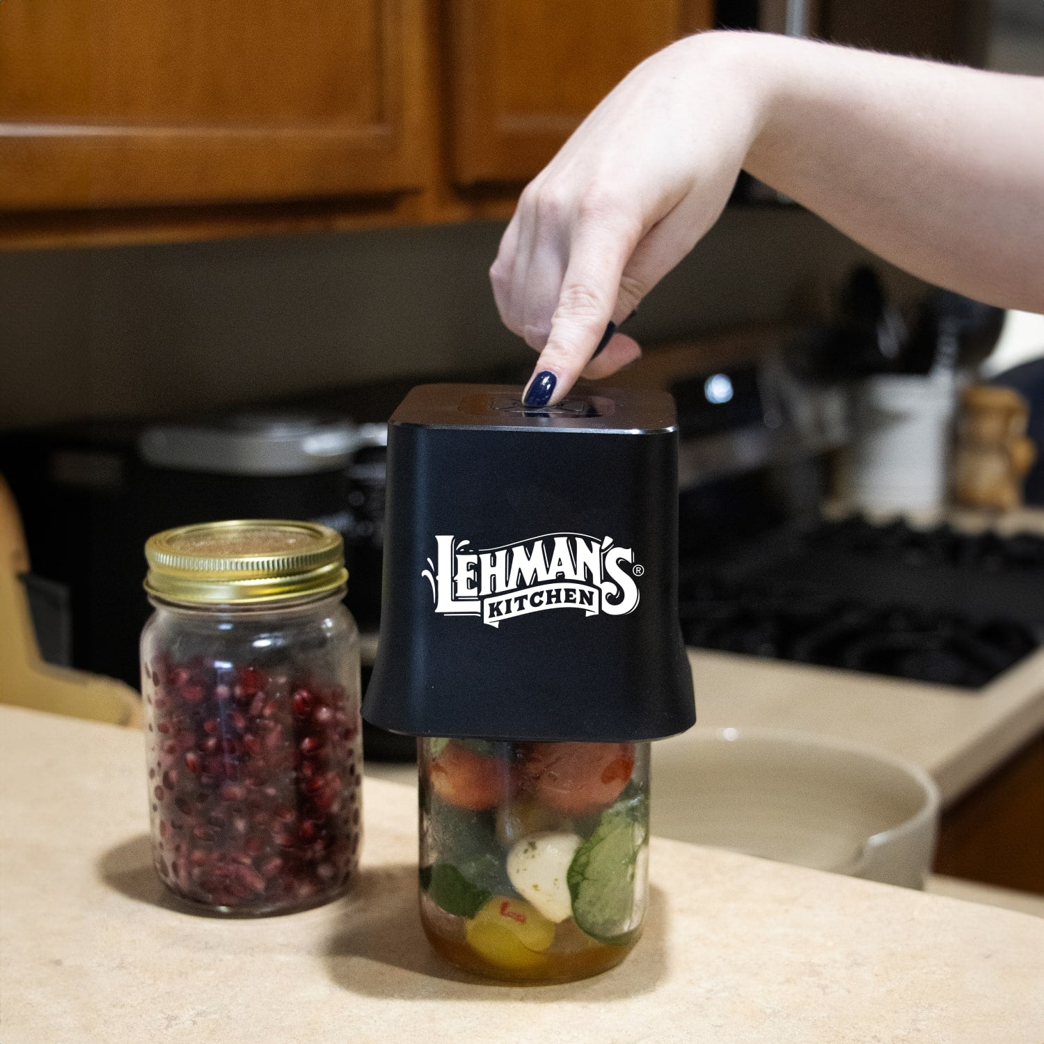 Hand pressing black cordless vacuum sealer on glass jar with vegetables, part of Small Kitchen Appliances and Kitchenware collections
