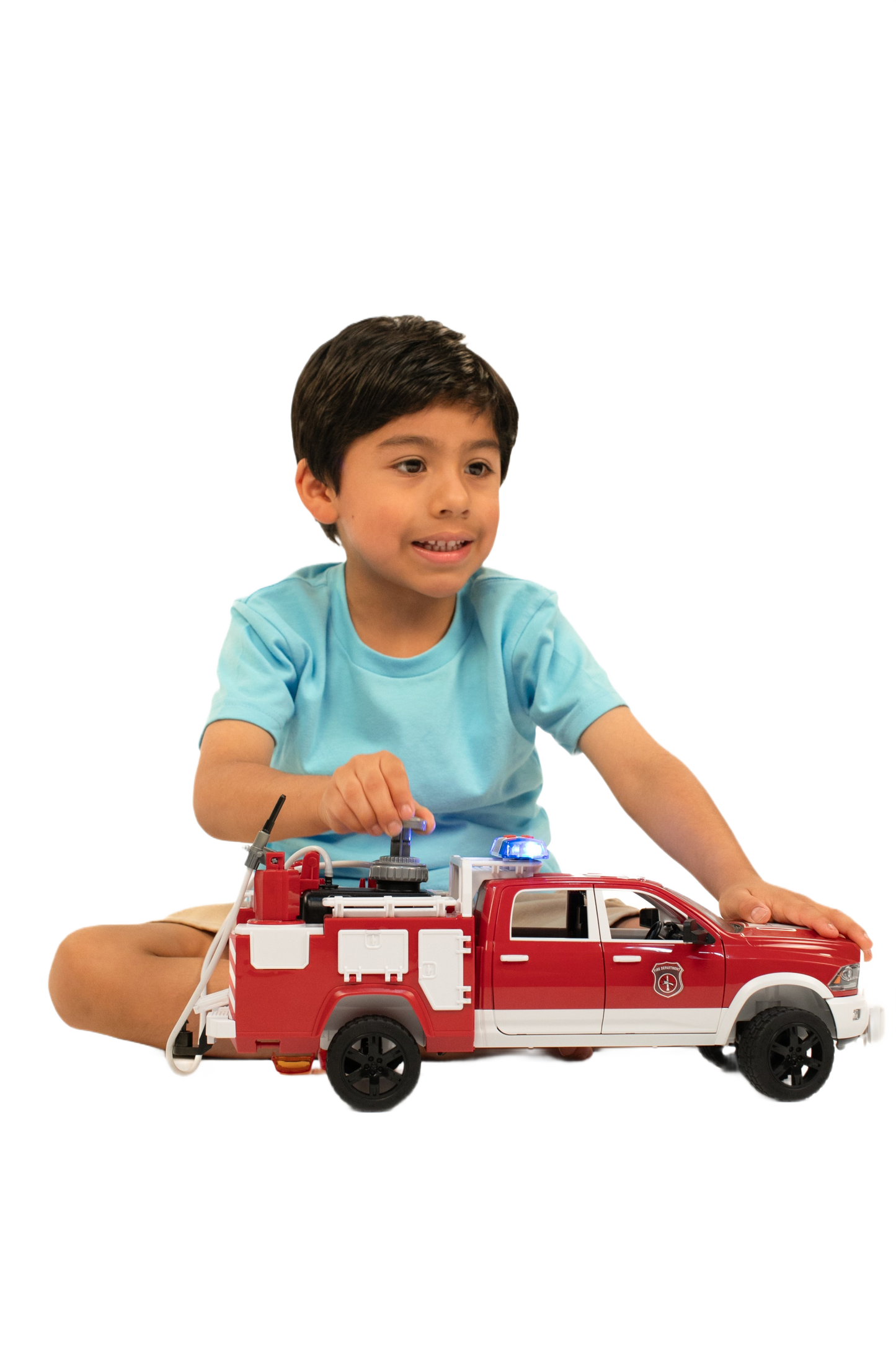 Young boy playing with red and white Bruder RAM fire rescue truck featuring a light and sound module