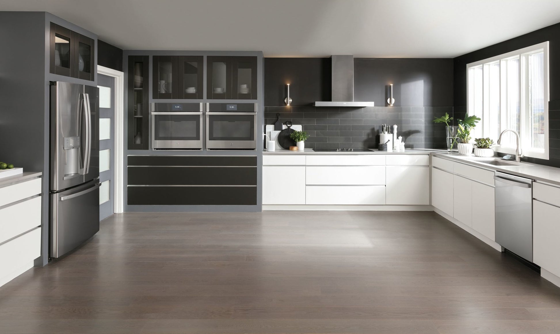 Modern kitchen with sleek white cabinetry, stainless steel appliances, and a stainless wall mount vent hood for home improvement
