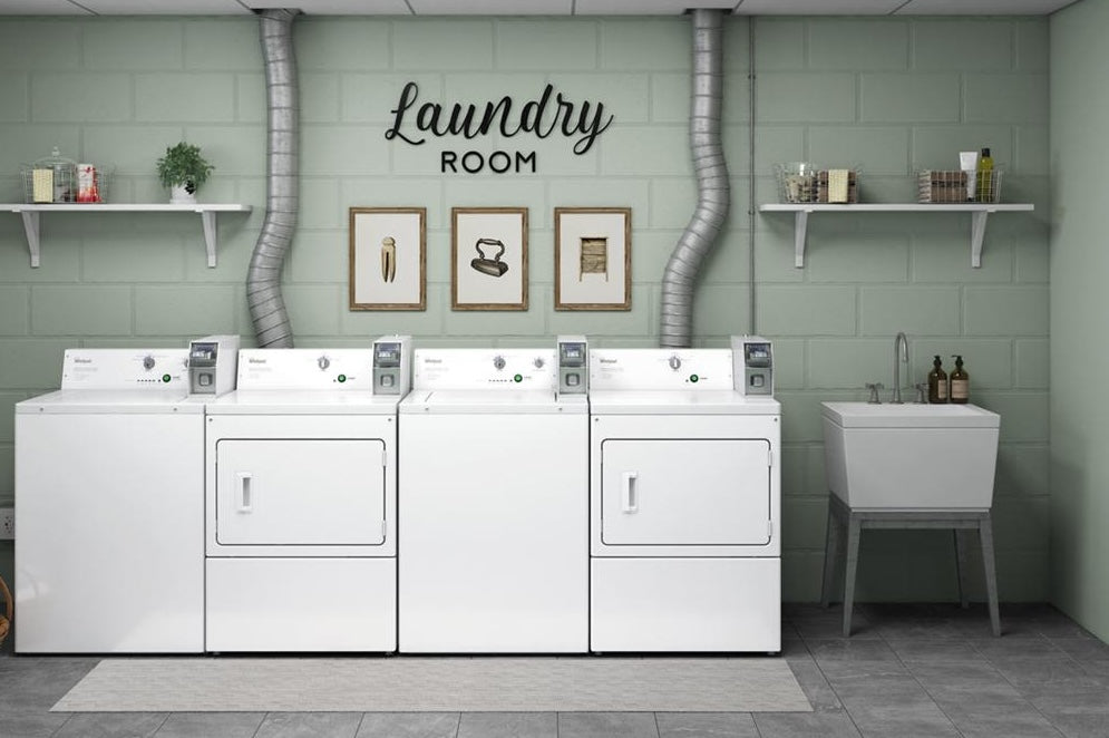 Commercial gas dryers with coin slide payment system in laundry room setting with utility sink and wall decor in appliances collection