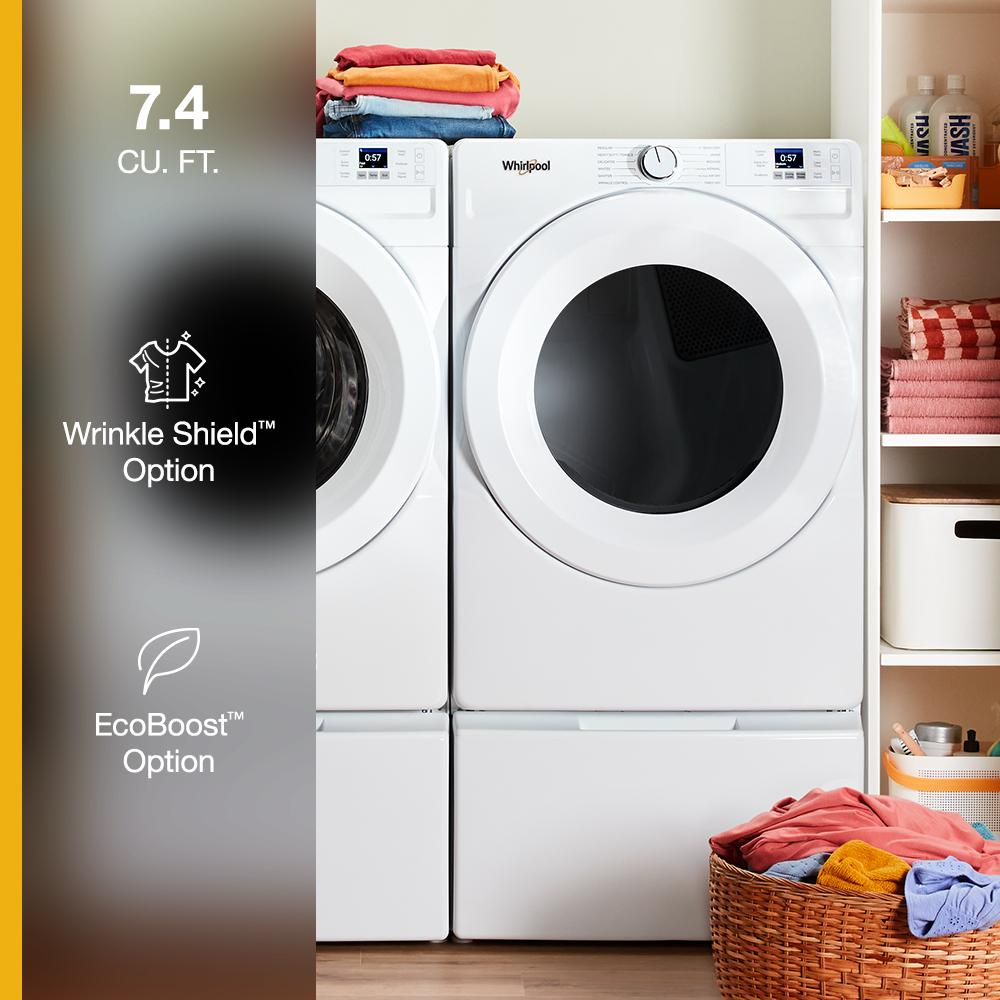 White front load gas dryer with digital display and knob next to matching washer in laundry room setting
