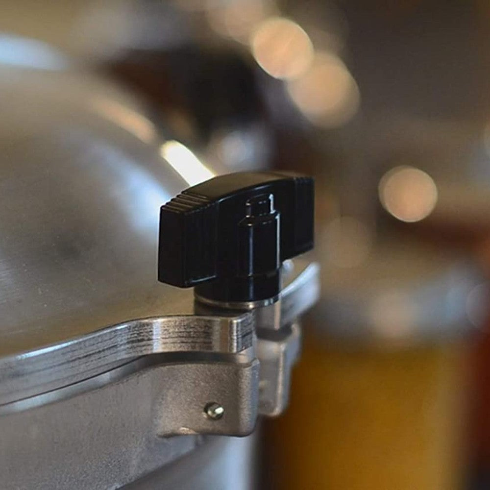 Close-up of black safety valve and secure metal clamp on aluminum pressure canner in kitchenware collections