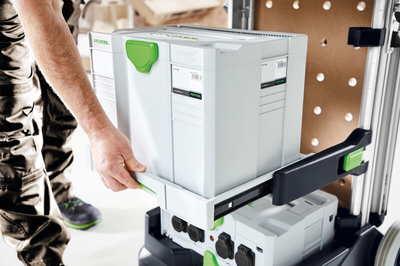Hand placing gray and green Festool pull-out drawer into black and silver mobile workcenter for workshop storage organization