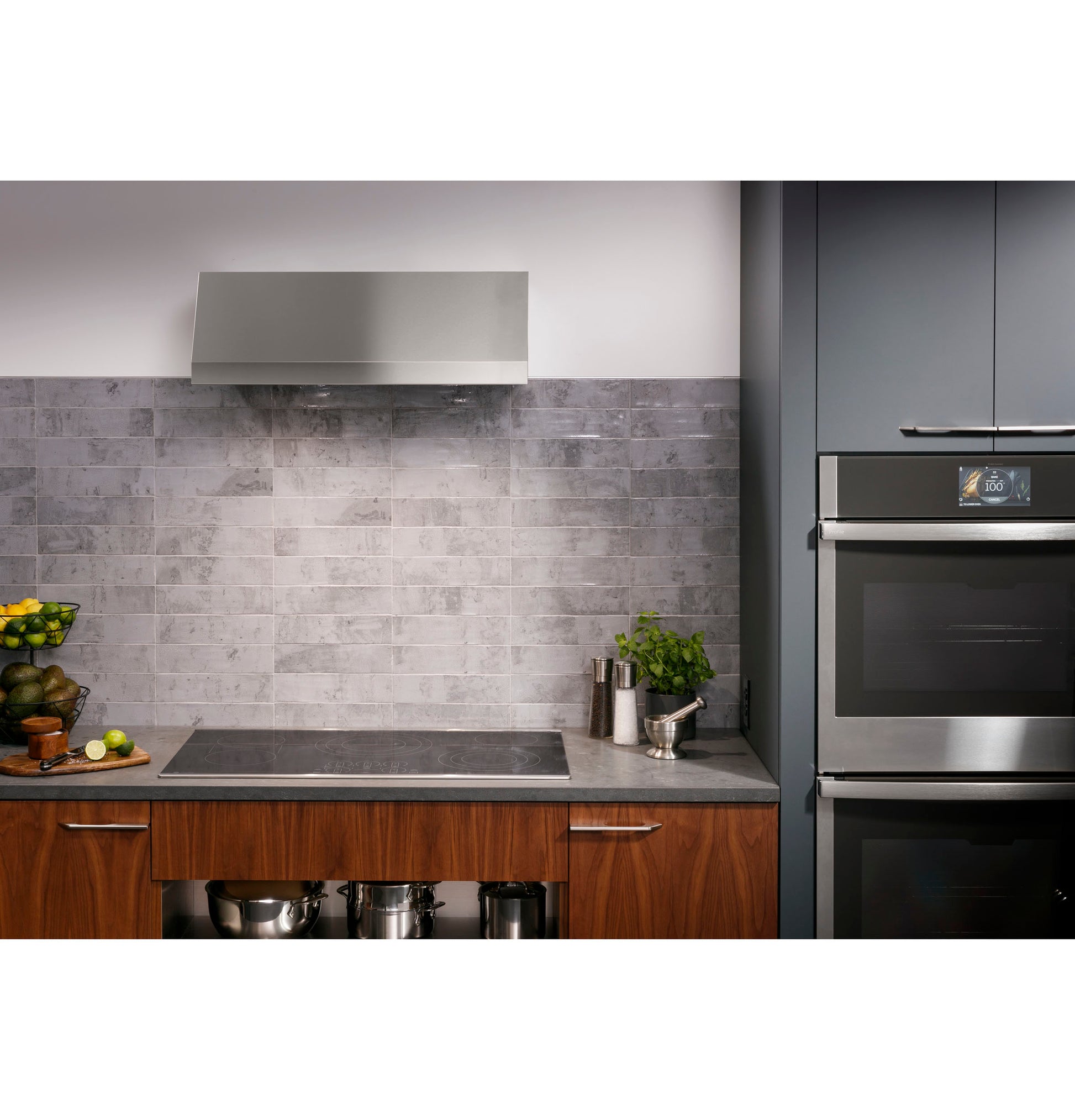 Modern kitchen featuring a built-in touch control cooktop with stainless steel range hood and wood cabinetry in home improvement setting