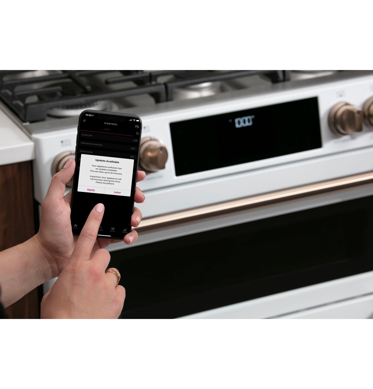 Person using smartphone app to update software on white smart slide-in gas double-oven range from Appliances collection