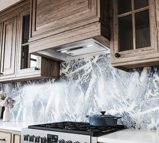 Under-cabinet stainless steel insert hood with LED lights installed above a stove in a contemporary kitchen setting