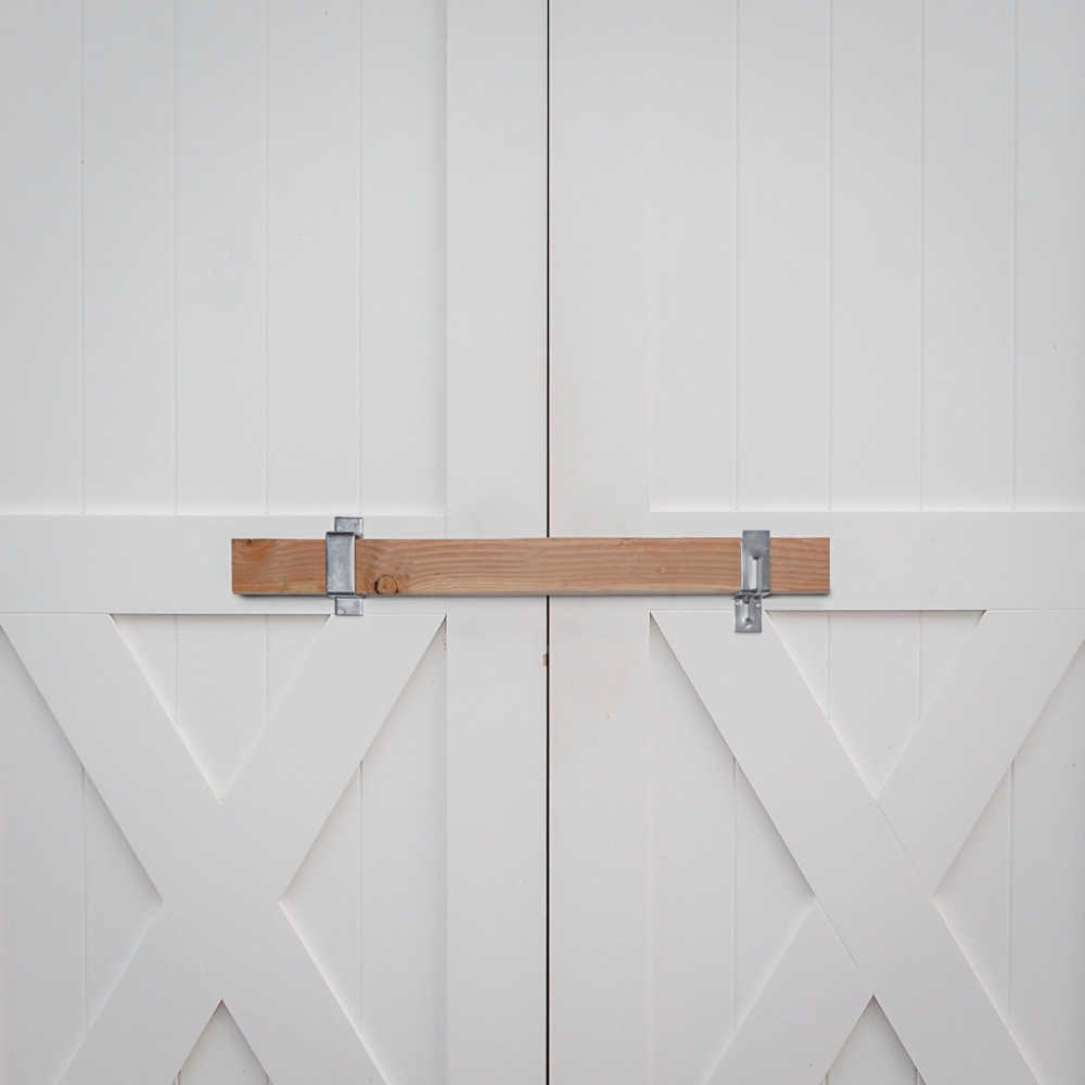 Zinc heavy duty closed bar holder securing 2x4 wood on white double doors for gate hardware and home improvement projects