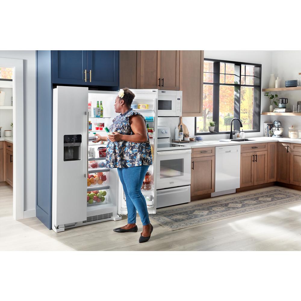 Woman selecting beverage from open side-by-side refrigerator with water dispenser in modern kitchen setting