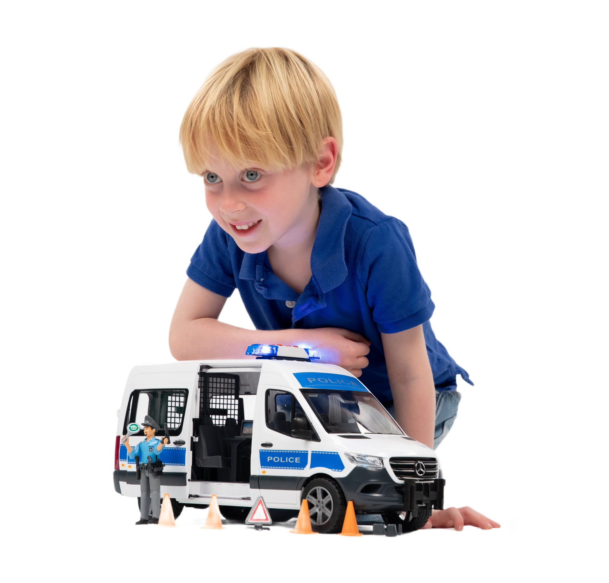 Young boy playing with white and blue MB Sprinter police emergency vehicle toy and traffic accessories