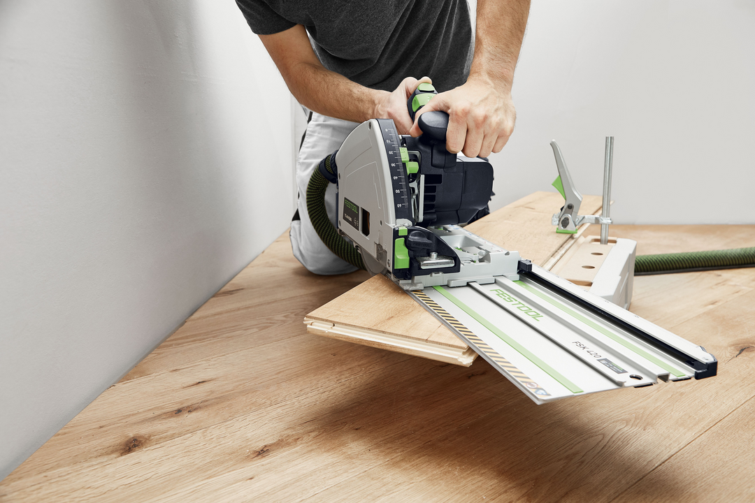 Man using Festool plunge cut track saw with guide rail for precise woodworking in home improvement power tools collection