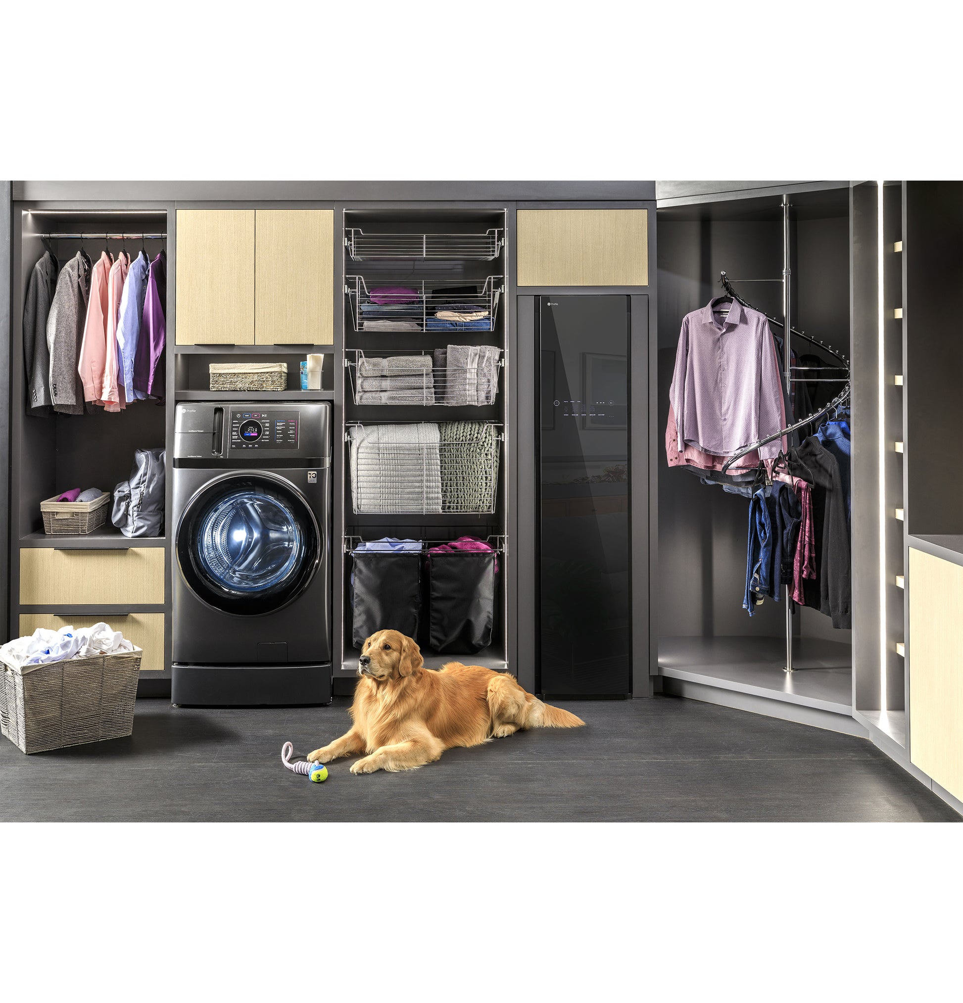 Modern laundry room with black front load washer, fabric refresh steam closet, organized shelves, and a dog resting on floor