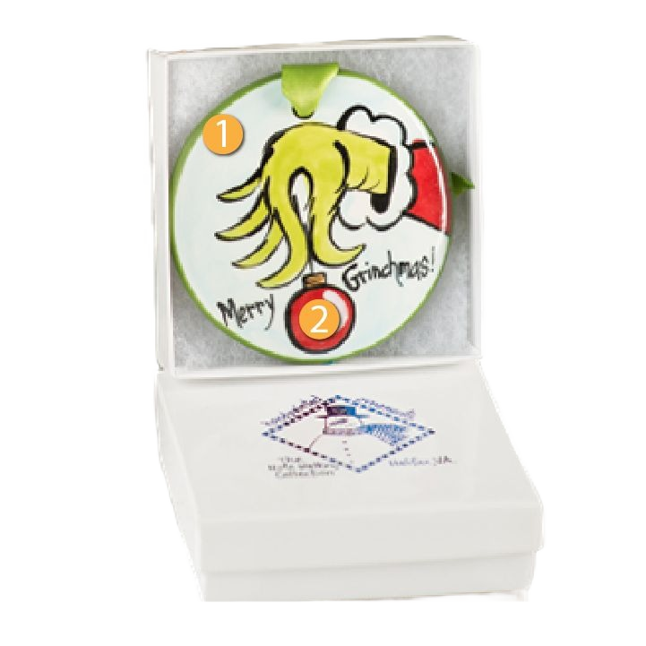 Hand-painted ceramic Christmas ornament featuring a whimsical Grinch hand holding a red bauble, gift boxed for holiday décor