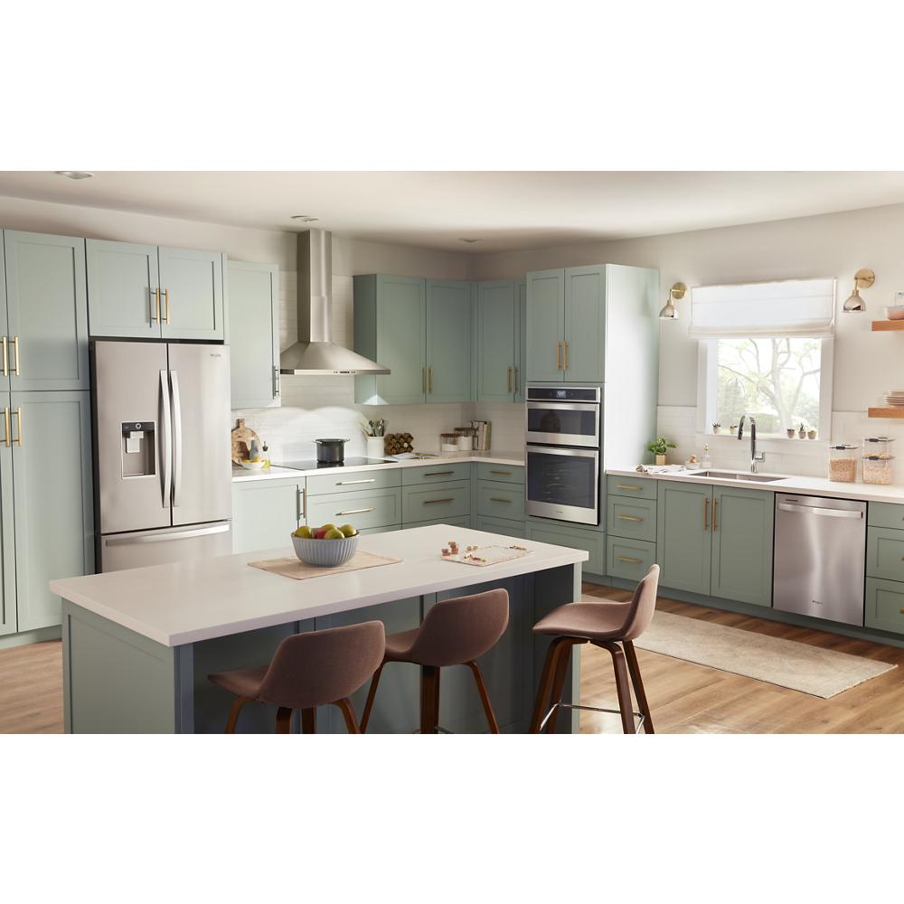 Bright kitchen with sage green cabinetry, stainless steel appliances, chimney wall mount range hood, and island seating area