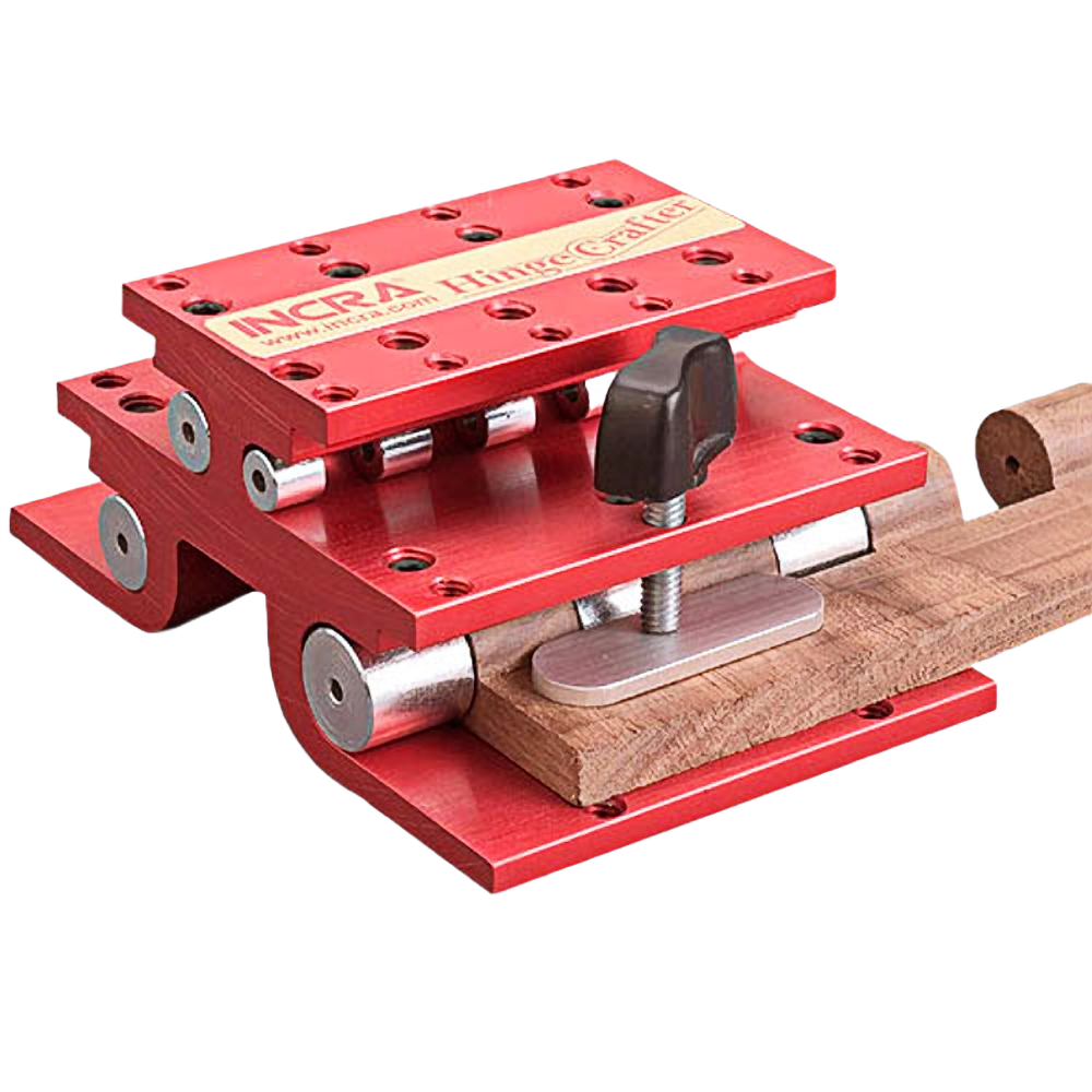 Red anodized aluminum hinge pin drilling guide clamping a wooden piece for precision woodworking tools accessory.
