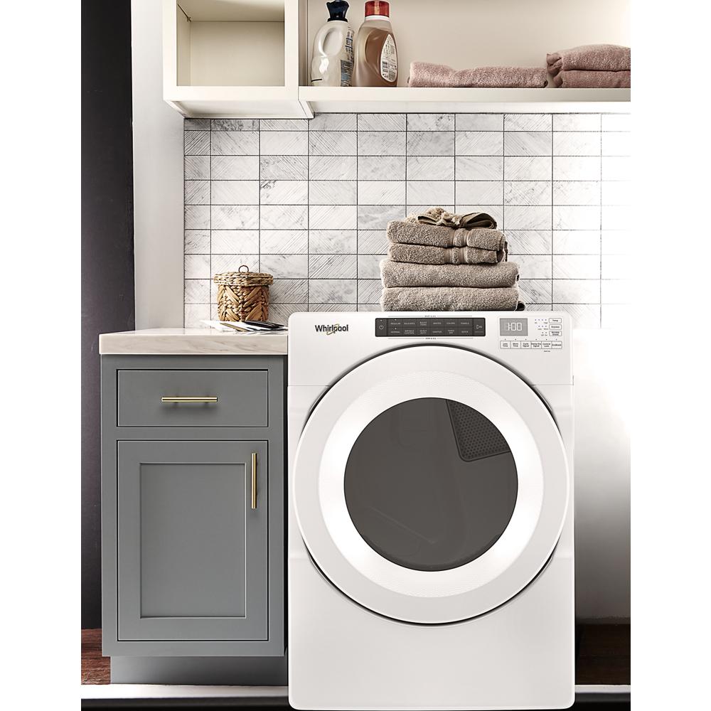 White front load electric dryer with intuitive controls next to gray cabinet in modern laundry room setting