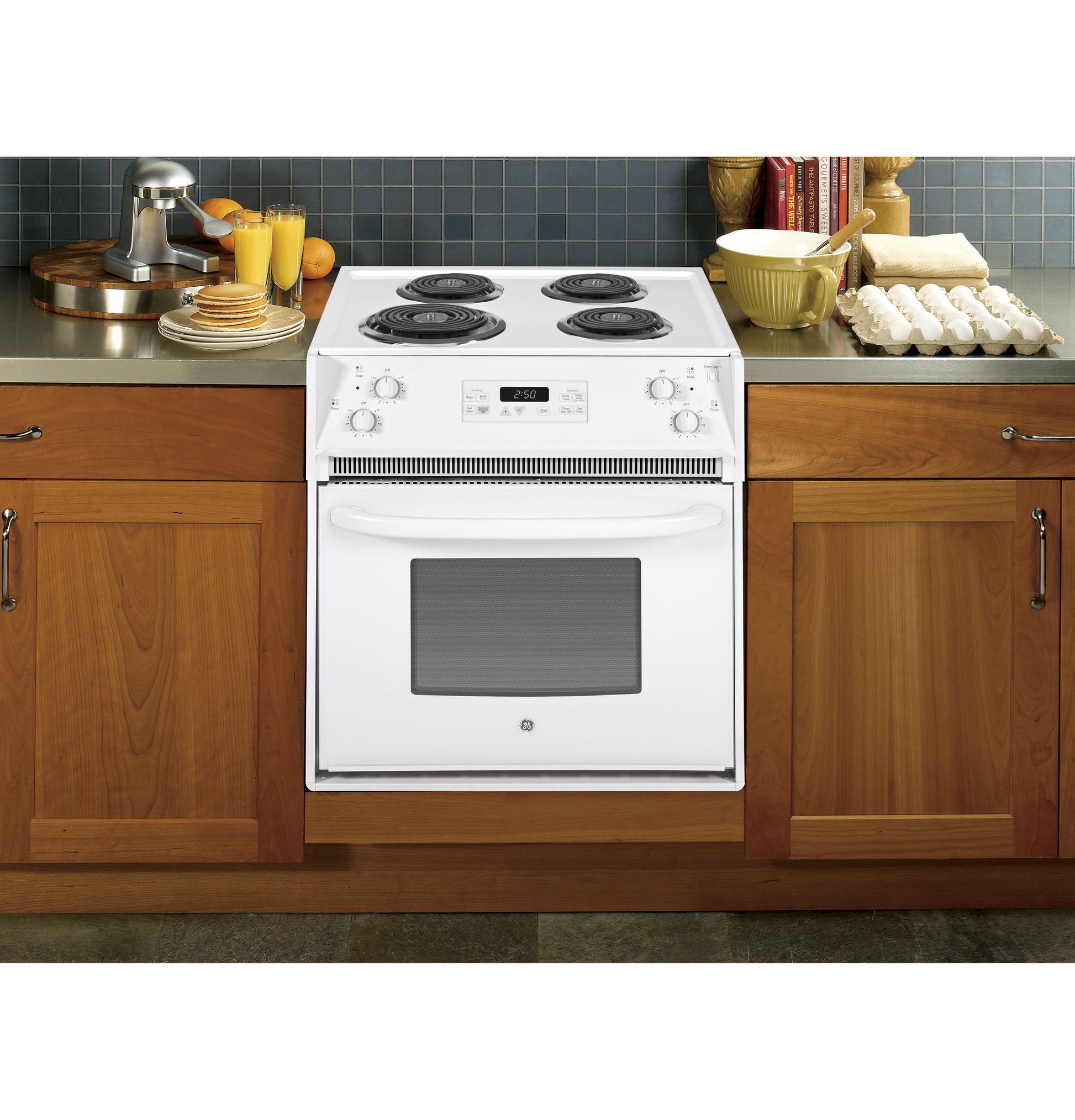 White electric range with coil burners and built-in oven integrated into wood kitchen cabinets in appliance collection