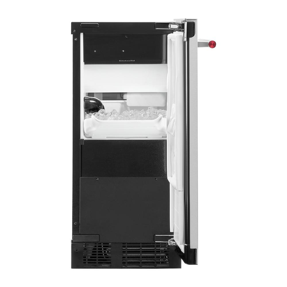 Open side view of black built-in 15" ice maker showing clear ice cubes in interior from KitchenAid appliances collection