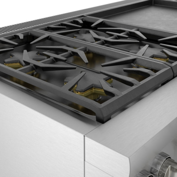 Close-up of stainless steel dual fuel range burner with black cast iron grates and brass gas burner caps in kitchenware collection