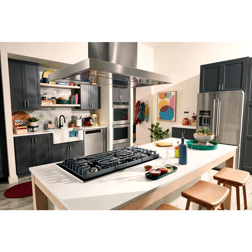 Contemporary kitchen with black glass gas cooktop installed on white island and dark cabinetry in home improvement setting