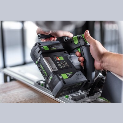 Person operating Festool cordless track saw with kickback stop on guide rail for power tools and home improvement