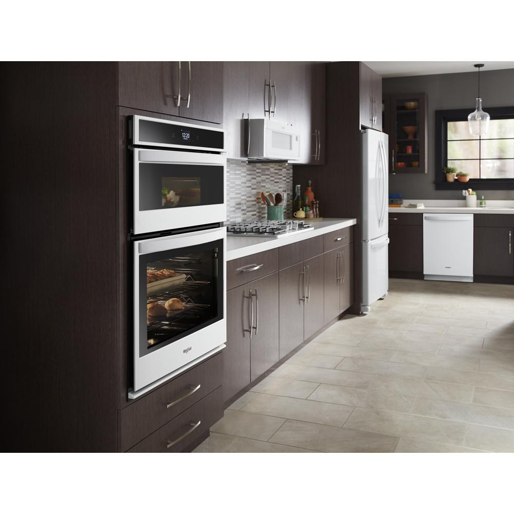 Modern kitchen featuring white built-in double oven and microwave with dark wood cabinetry and light tiled flooring from appliances collection