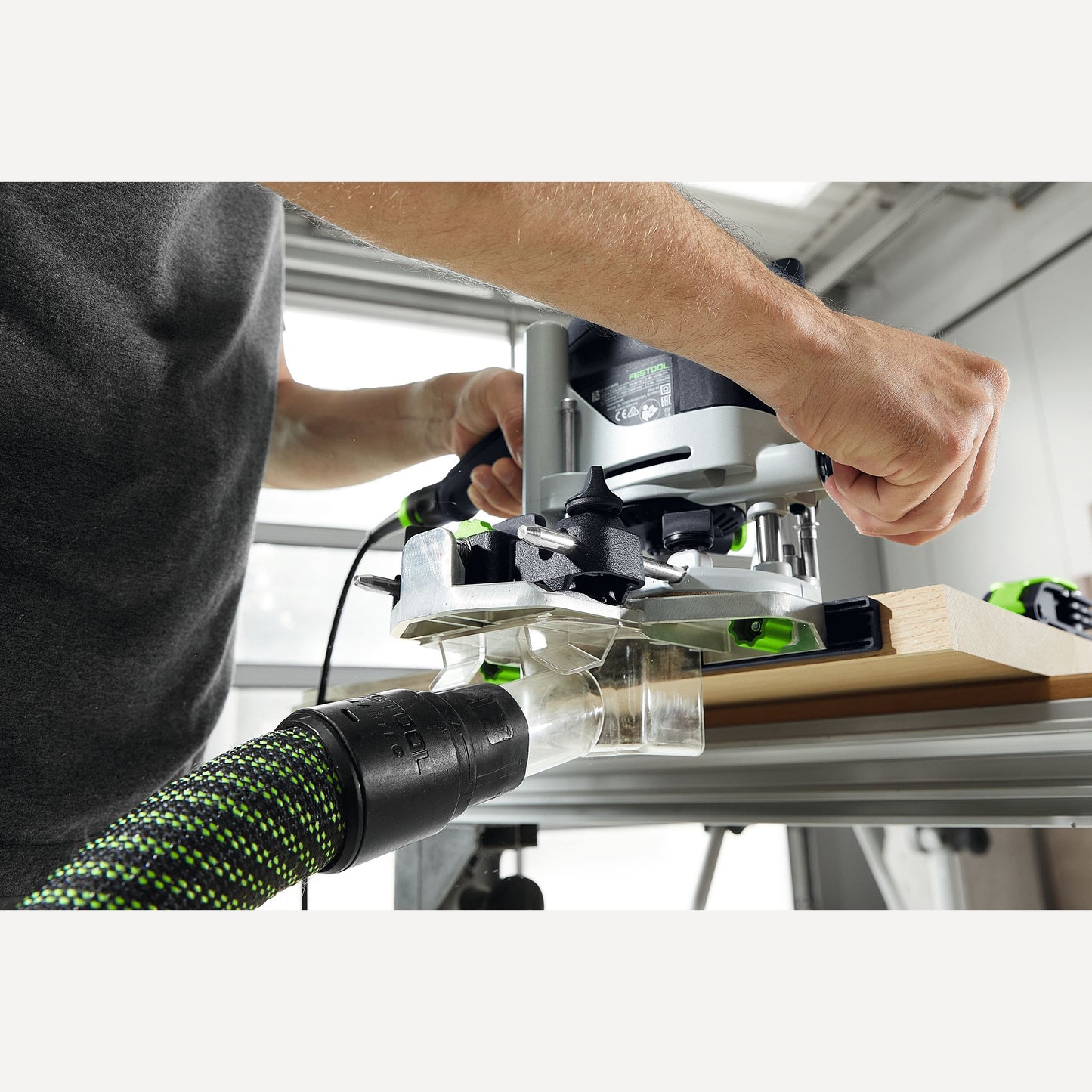 Person operating a festool woodworking router with dust extraction on wood using tool accessory from under $100 collection