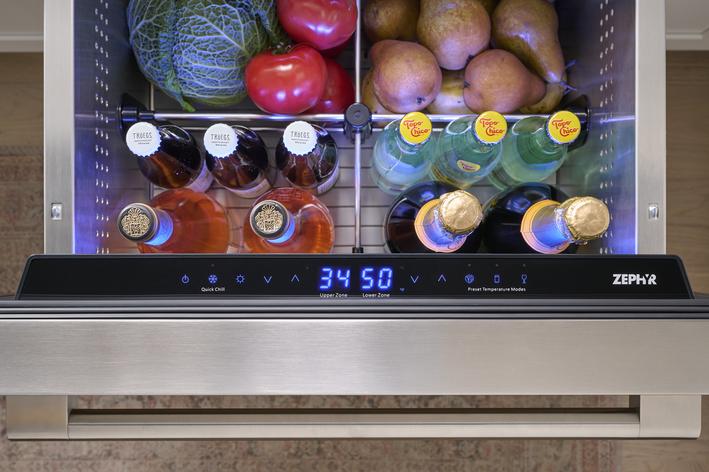 Under-counter stainless steel dual zone refrigerator drawer open with beverages and produce in kitchen appliance collection