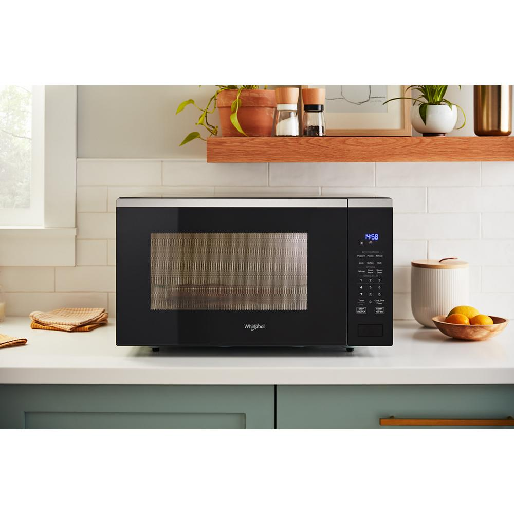 Black sensor microwave with digital display and control panel on kitchen countertop in modern home appliance setting