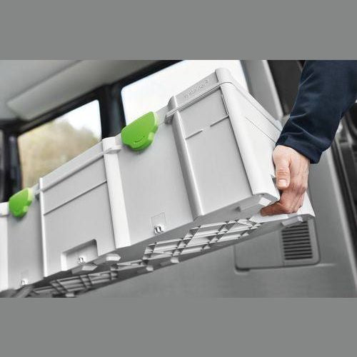 Person loading large gray and green modular tool storage box into vehicle for workshop and jobsite organization