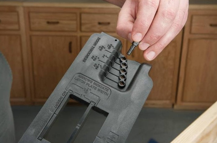 Hand holding metal pin above black plastic strike and latch woodworking tool accessory under $50 collection