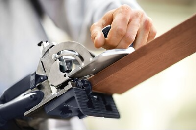 Close-up of woodworking power tool making precise cuts on hardwood board for home improvement and carpentry projects