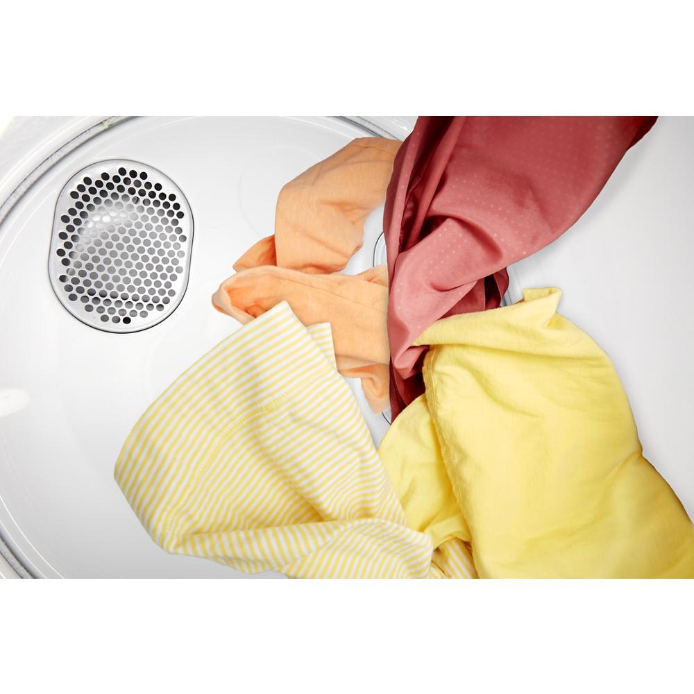 Inside view of compact dryer drum containing colorful laundry in soft yellow, orange, and red tones for apartment use