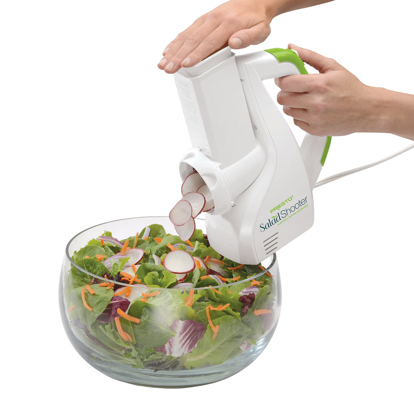White and green electric slicer shredding radishes into a glass bowl with mixed salad in kitchen gadgets collections