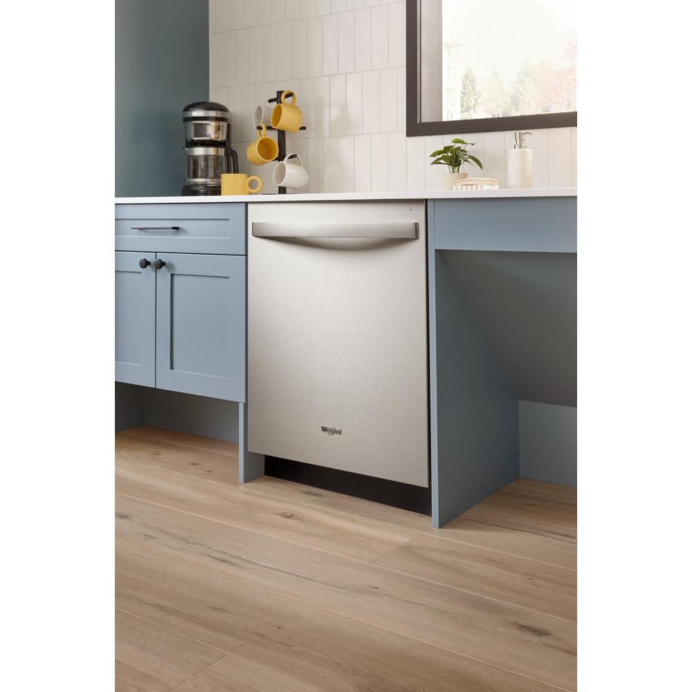 Built-in stainless steel dishwasher with curved handle integrated into light blue kitchen cabinetry in appliances collection