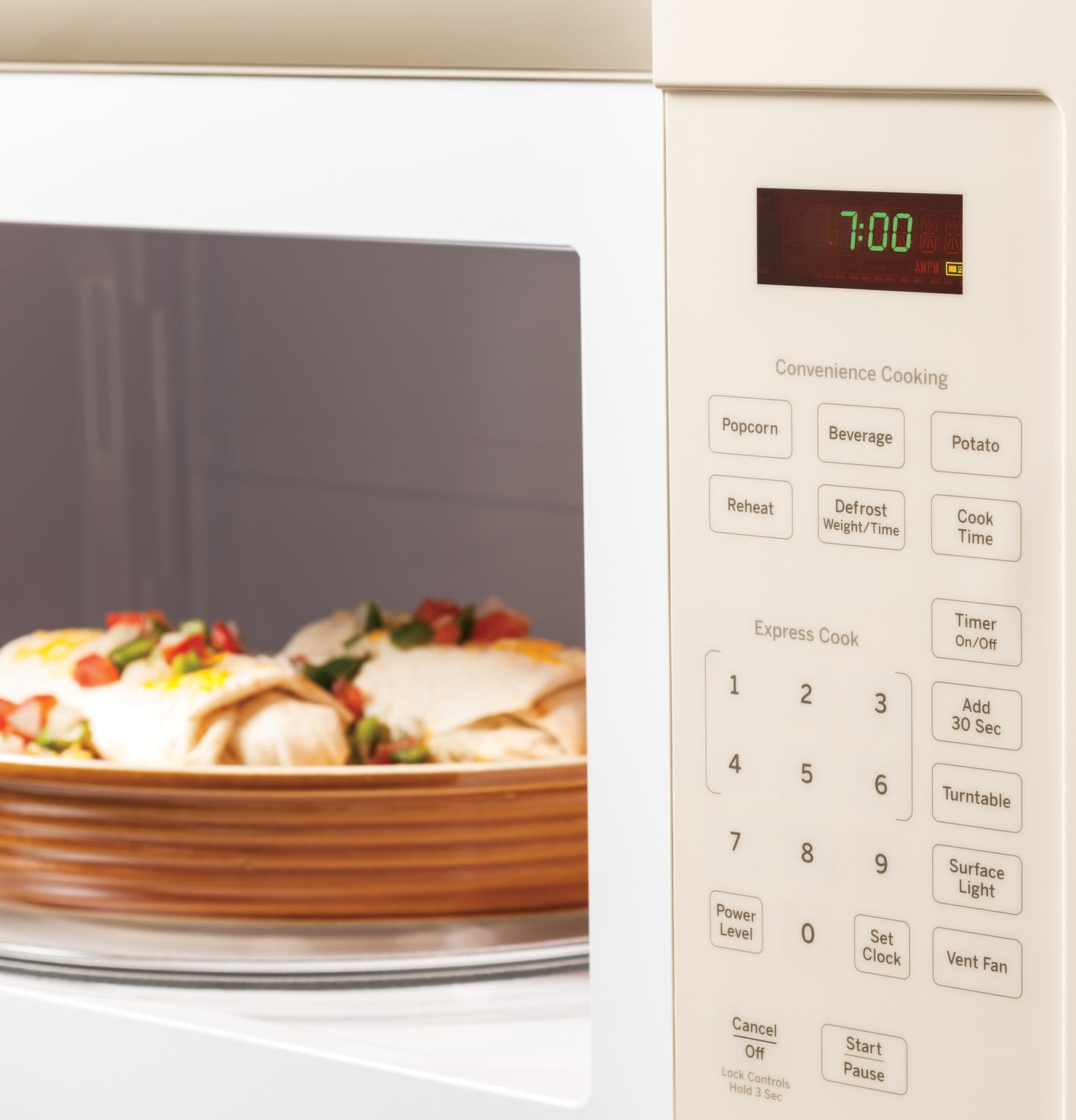 Close-up of beige over-the-range microwave keypad with preset cooking options, digital timer, and food inside on rotating plate