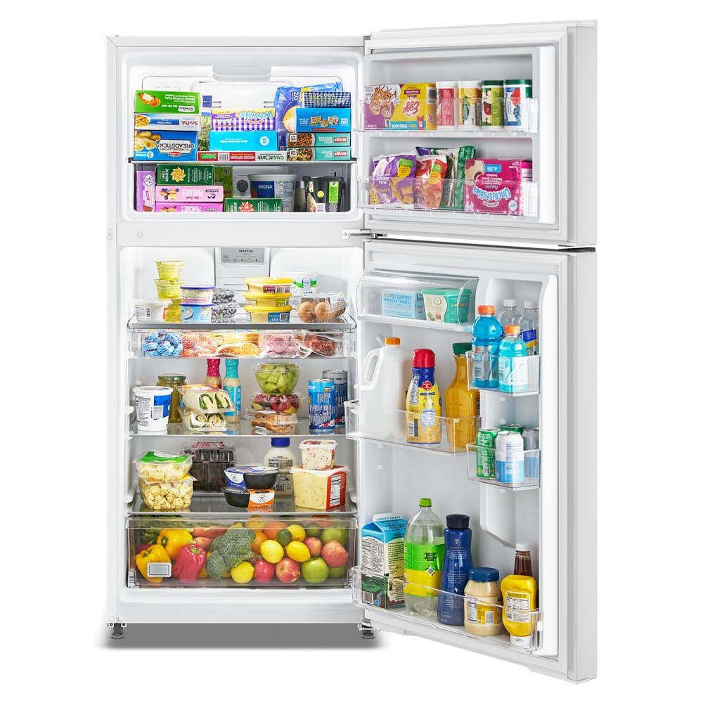 Open white top-freezer refrigerator fully stocked with food and beverages in a kitchen appliance setting