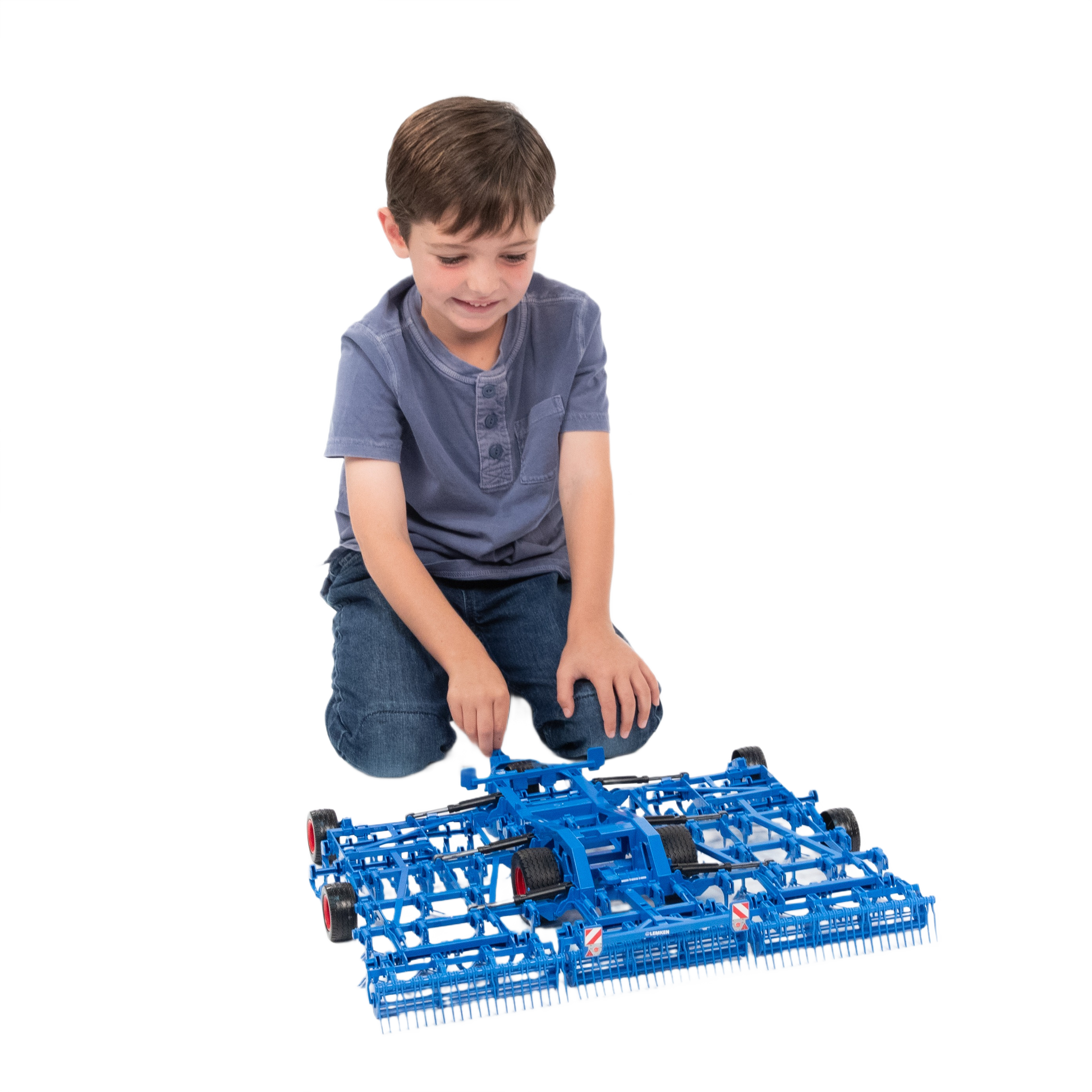 Child playing with detailed blue model cultivator toy for tools and home improvement use
