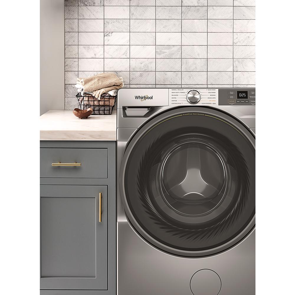 Silver front load washer next to gray cabinetry with towels in a laundry room from Front Load Washers collection